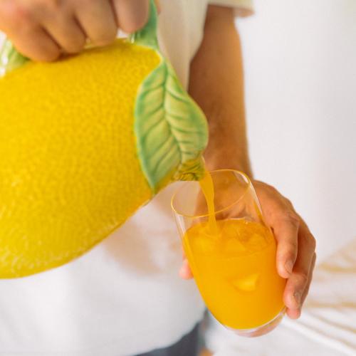 a person is pouring a glass of orange juice at Quinta Dona Matilde in Peso da Régua