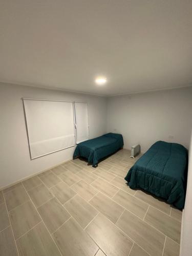 um quarto com 2 camas e piso em azulejo em Casa barrio cerrado Las Lomas em Monte Hermoso