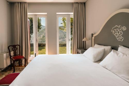 a bedroom with a large bed with a large window at Quinta Dona Matilde in Peso da Régua