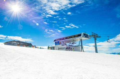 a ski lift sitting on top of a snow covered slope at Gerlitzen-Apartments in Kanzelhöhe