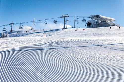 a snow covered ski slope with a ski lift at Gerlitzen-Apartments in Kanzelhöhe