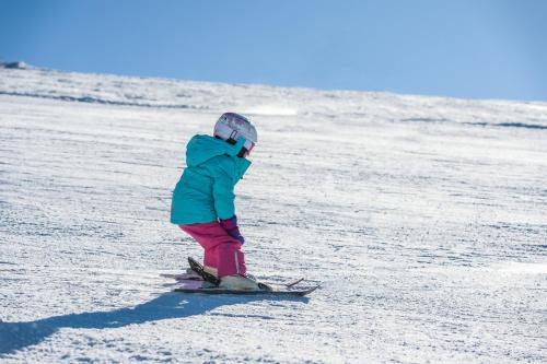 a young child is skiing in the snow at Gerlitzen-Apartments in Kanzelhöhe