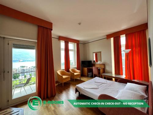 Habitación de hotel con cama y balcón en E-Rooms Minusio en Locarno