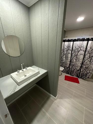 a bathroom with a sink and a mirror at Casa barrio cerrado Las Lomas in Monte Hermoso