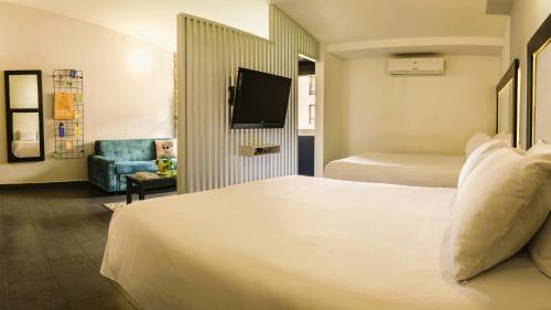 a hotel room with a bed and a tv at Hotel El Peñon by Bithotels in Cali