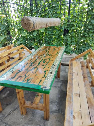 ロゼネッツにあるAltay Guest Houseの木製のピクニックテーブル(緑の上部とベンチ2台付)