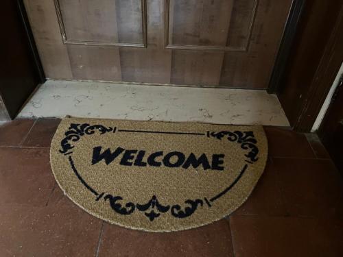 un tappetino di benvenuto sul pavimento di fronte a una porta di Alloggio MARIPOSA a Borgo San Dalmazzo