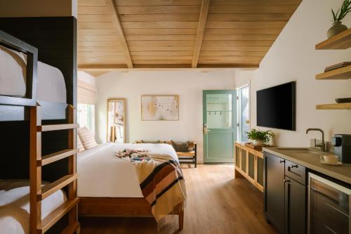 a bedroom with a bed and a desk with a television at Sonder Woods Cove in Laguna Beach