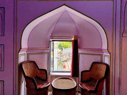 2 sillas y una mesa en una habitación con ventana en Hotel Kota kunj Heritage en Pushkar