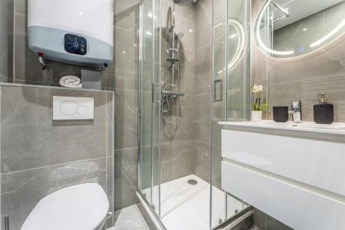 y baño con ducha, aseo y lavamanos. en Cozy flat Paris centre, en París
