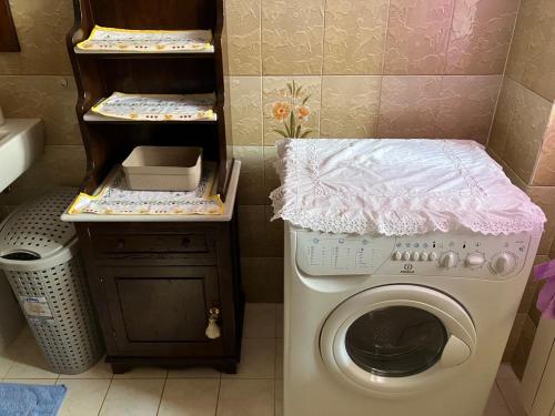 una lavanderia con lavatrice e lavandino di Alloggio MARIPOSA a Borgo San Dalmazzo