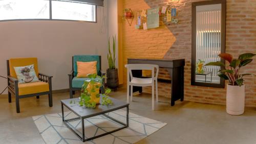 uma sala de estar com cadeiras, uma mesa e uma secretária em Hotel El Peñon by Bithotels em Cali