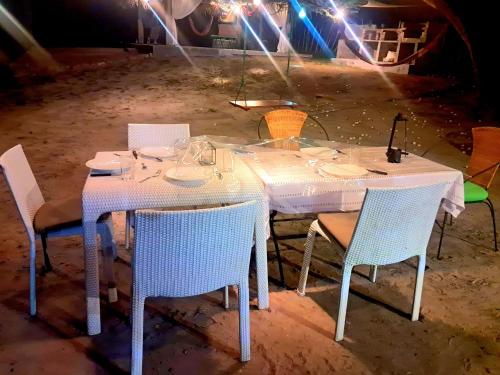 a table with chairs and a white tablecloth on it at Nilamba Beach Resort in Kovvankulam