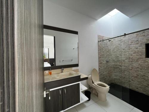 a bathroom with a toilet and a sink and a shower at Monte Escondido-Condominio Campestres Altos de Komulá - Anapoima in Anapoima