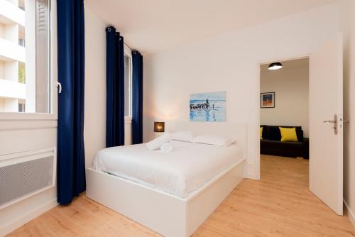 une chambre blanche avec un lit et une fenêtre dans l'établissement Le Bachelier - T2 proches Ramblas de Toulouse, à Toulouse