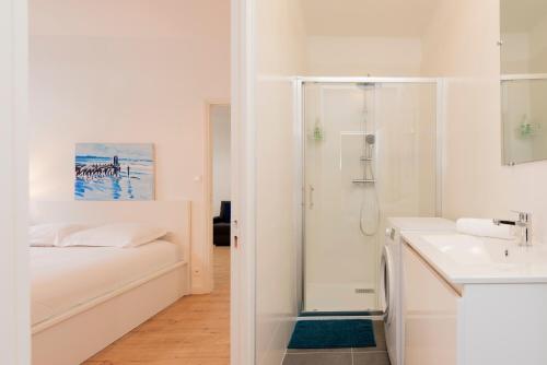 une salle de bain blanche avec une douche et un lavabo dans l'établissement Le Bachelier - T2 proches Ramblas de Toulouse, à Toulouse