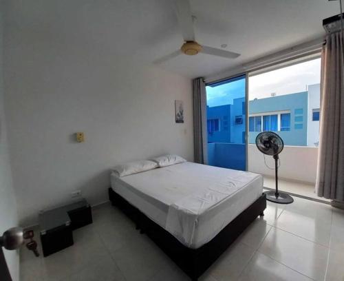 a bedroom with a bed and a window with a fan at Linda Casa de Descanso in Nilo