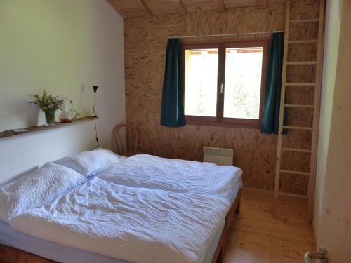Schlafzimmer mit einem Bett und einem Fenster in der Unterkunft Gasthaus Heiligkreuz in Binn