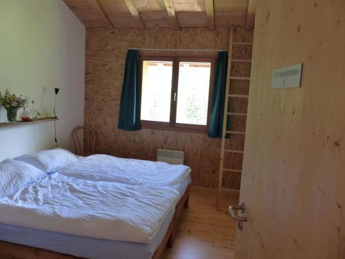 a bedroom with a bed and a window at Gasthaus Heiligkreuz in Binn