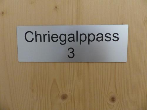 a sign on a wooden wall with the word chicago pass at Gasthaus Heiligkreuz in Binn