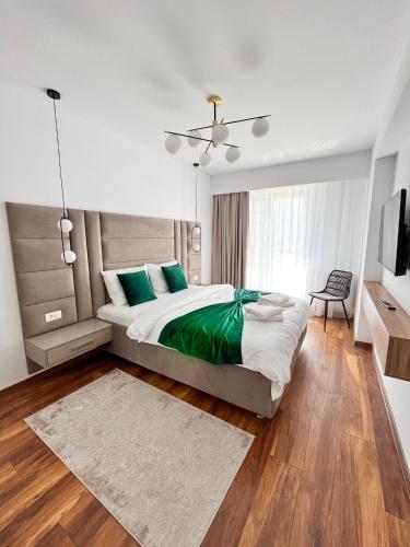 布拉索夫的住宿－Alegria Avantgarden Brasov，一间卧室配有一张带绿色枕头的大床