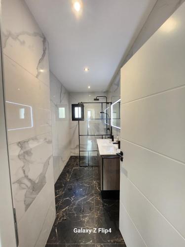 une salle de bain avec un lavabo et un miroir dans l'établissement JOUBLIE TOUT! CALME BORD MER SHOPPING, SPA MÉNAGE LINGE WIFI 2 PARKING INCLUS 8 personnes, à Vias