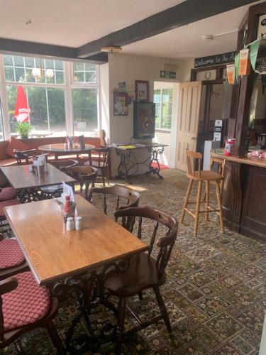 a restaurant with tables and chairs in a room at Alby horseshoes inn in Erpingham