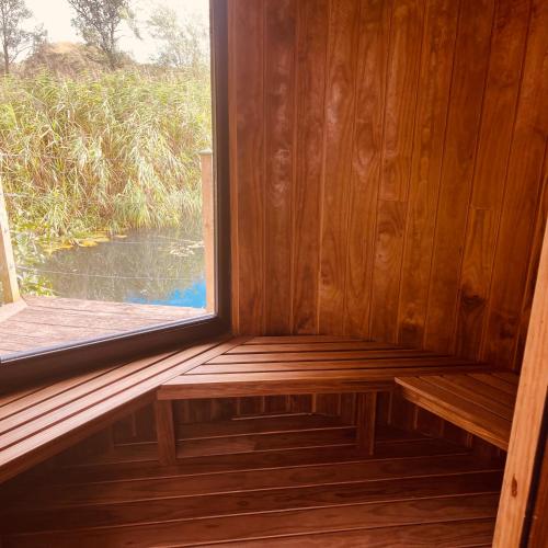a bench in a wooden room with a window at The Dairy in Castle Douglas