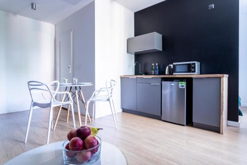 a kitchen with a table with a bowl of fruit at Victus Apartamenty Playa&Relax in Sopot