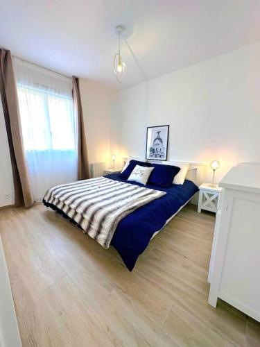 une chambre avec un lit avec des draps bleus et blancs dans l'établissement 7mn de Deauville Jardin Wifi Box TV, à Saint-Arnoult