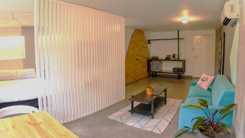 a living room with a blue couch and a table at Hotel El Peñon by Bithotels in Cali