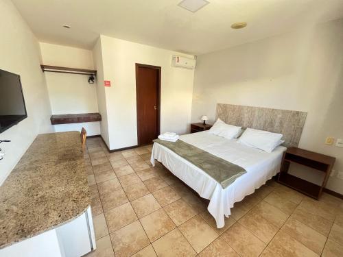um quarto de hotel com uma cama e uma televisão em Pousada Maristella em Salvador
