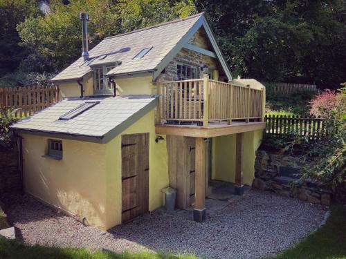 a small yellow house with a deck on it at The Barley Mill in Bude
