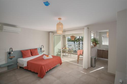 1 dormitorio con 1 cama y balcón con mesa en Kaouanne, en Les Trois-Îlets