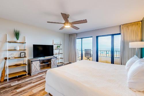 a bedroom with a bed and a flat screen tv at Surf Dweller 203 in Fort Walton Beach