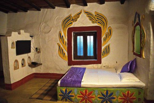 Srī NiketanにあるRaktokorobi Karu Gramの窓付きの部屋にベッド付きのベッドルーム1室があります。