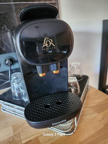 une cafetière noire assise sur une table dans l'établissement JOUBLIE TOUT! CALME BORD MER SHOPPING, SPA MÉNAGE LINGE WIFI 2 PARKING INCLUS 8 personnes, à Vias