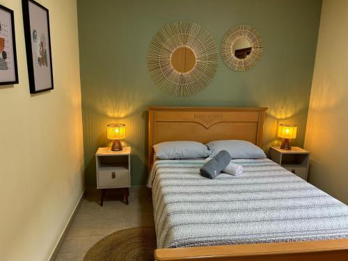 a bedroom with a bed with two night stands and two lamps at Lindo apartamento no centro de Águas de Lindóia in Águas de Lindóia