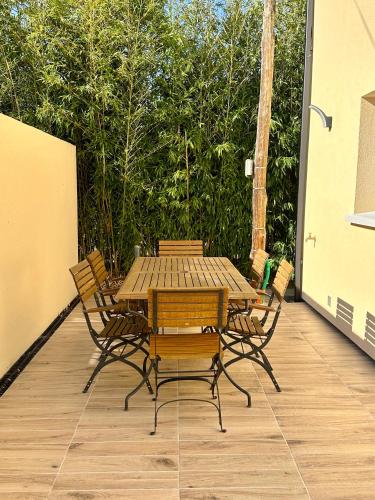 a wooden table and chairs on a patio at La Halte Occitane - Classé 3 étoiles - Pour 6 personnes, 3 chambres, parking, terrasse, tout inclus in Montauban