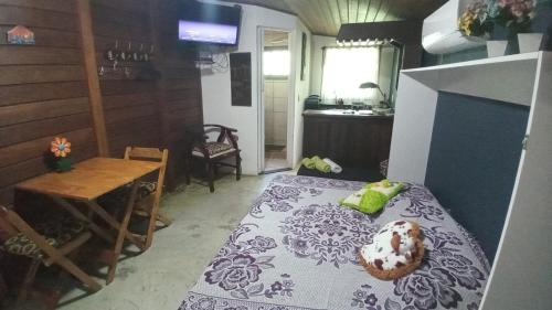 Morada do Canal Suites em Búzios في بوزيوس: غرفة بها سرير وطاولة وطاولة بجانب السرير
