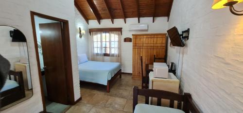 um pequeno quarto com uma cama e um pequeno quarto em Termas Posada del Siglo XIX em Termas del Daymán