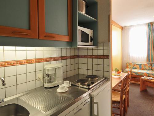 - une cuisine avec évier et cafetière sur le comptoir dans l'établissement Studio divisible fonctionnel · Accès direct aux pistes · Animaux admis - FR-1-181-2251, à La Plagne Tarentaise