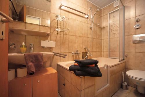 ein Badezimmer mit einem Waschbecken, einer Badewanne und einem WC in der Unterkunft Ferienwohnung Reindler in Fischen im Allgäu