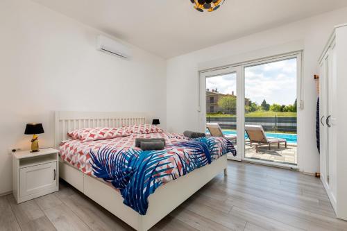 KršanにあるVilla Blue Lagoon - Private Pool and Whirlpoolのベッドルーム1室(ベッド1台付)が備わります。プールの景色を望めます。