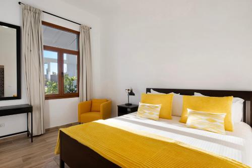 una camera da letto con un letto con cuscini gialli e una sedia gialla di Casa Camino La Estrella a Breña Alta