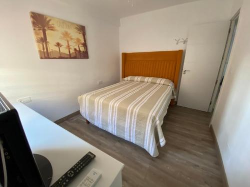 a small bedroom with a bed and a desk at Vacaciones en familia o amigos in Málaga