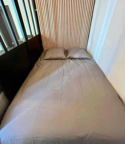 un petit lit dans une chambre avec une fenêtre dans l'établissement Appartement centre-ville Annecy, à Annecy