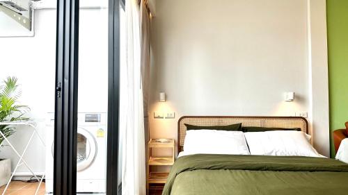 a bedroom with a bed and a green wall at The Tangerine Guesthouse in Bangkok