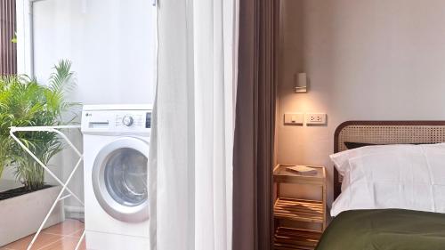a bedroom with a washer and a washing machine at The Tangerine Guesthouse in Bangkok