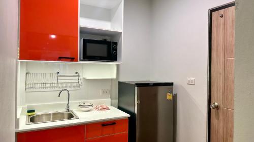 a small kitchen with a sink and a refrigerator at The Tangerine Guesthouse in Bangkok